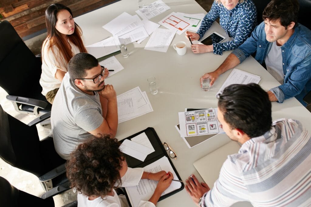 pessoas discutindo em uma mesa com papeis